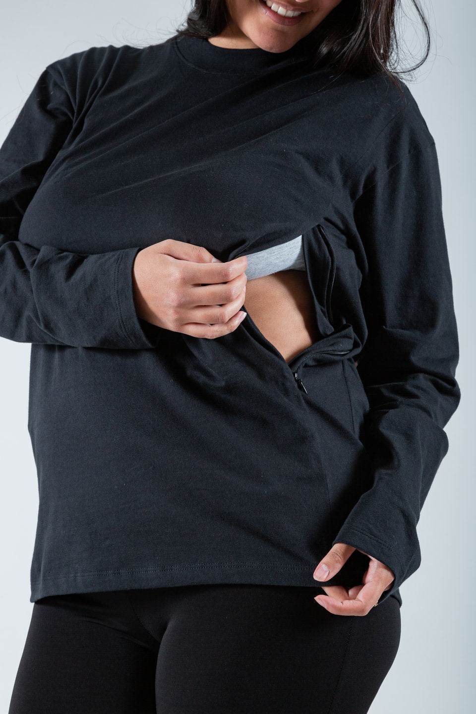 Polera de lactancia Tere en color negro, con mangas largas y cierres invisibles, hecha de algodón Pima Peruano, mostrando funcionalidad.