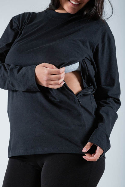 Polera de lactancia Tere en color negro, con mangas largas y cierres invisibles, hecha de algodón Pima Peruano, mostrando funcionalidad.