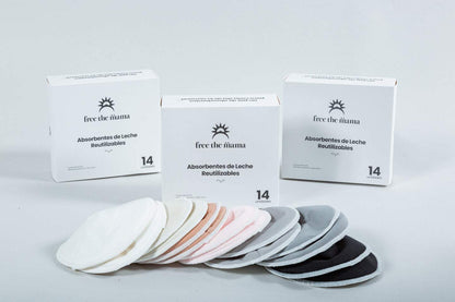Absorbentes de leche reutilizables en varios colores, con diseño anatómico y capa impermeable, junto a su empaque y bolsas para lavado y almacenamiento.