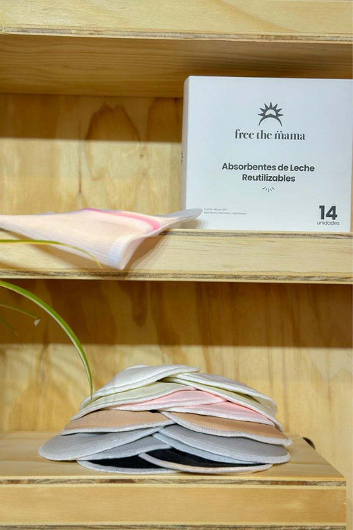 Absorbentes de leche reutilizables en estante de madera.