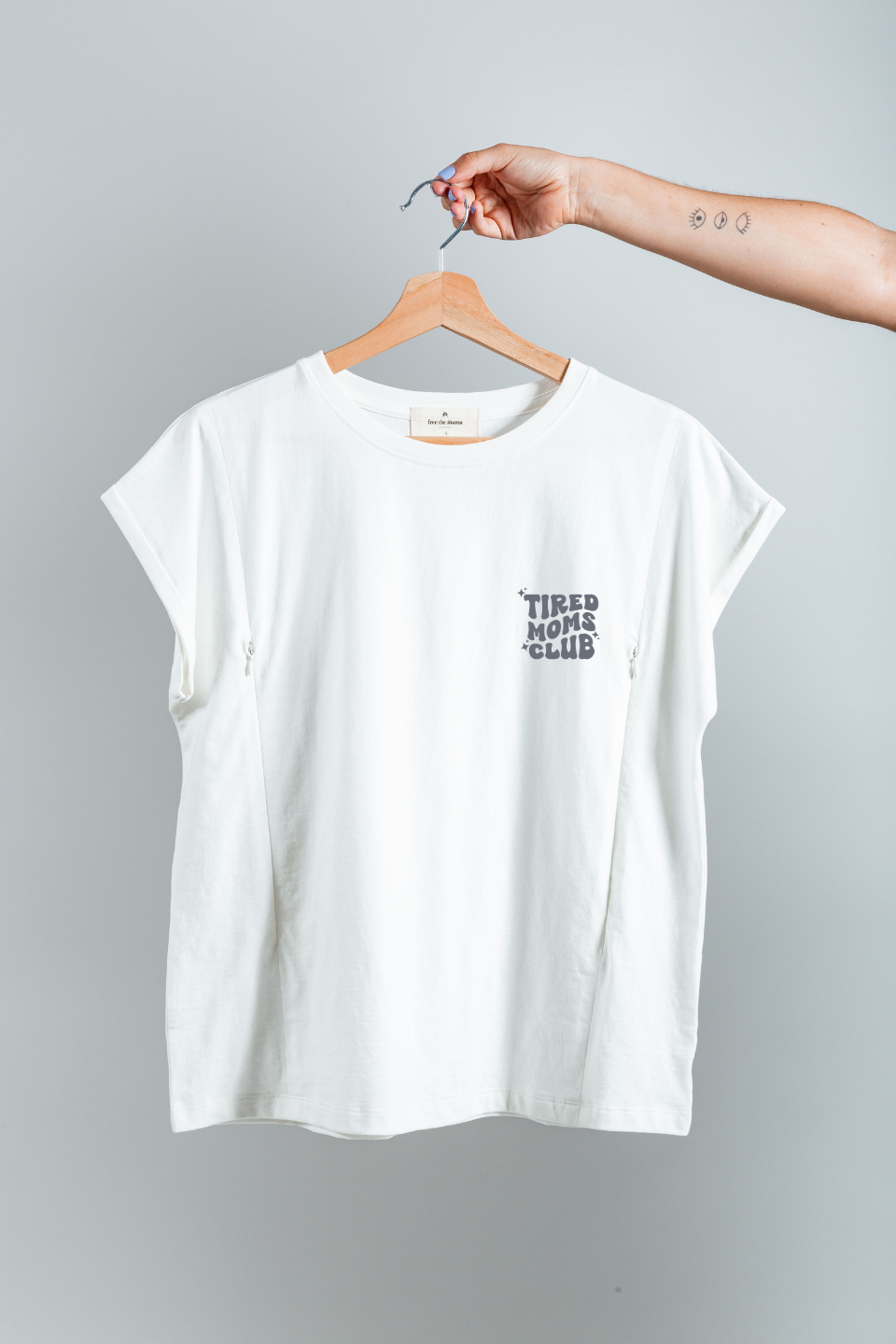 Polera de lactancia Sahr blanca con diseño "Tired Moms Club", hecha de algodón Pima Peruano.